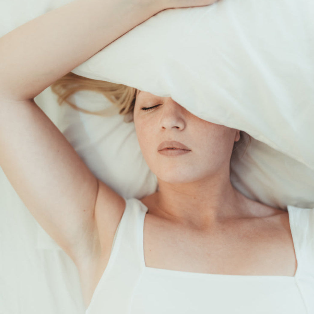 ung kvinne som sover rolig under hvit dyne, støtter naturlig søvn og avslapning med seda plus fra herba plus