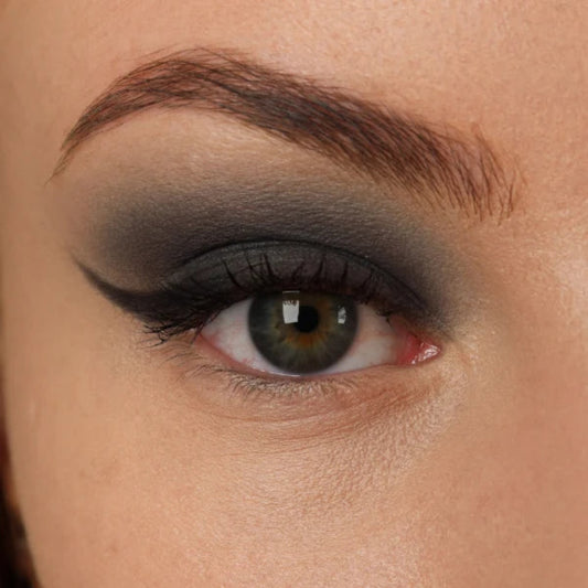 Nærbilde av et øye med mørk koksgrå øyenskygge og sort eyeliner med vinge