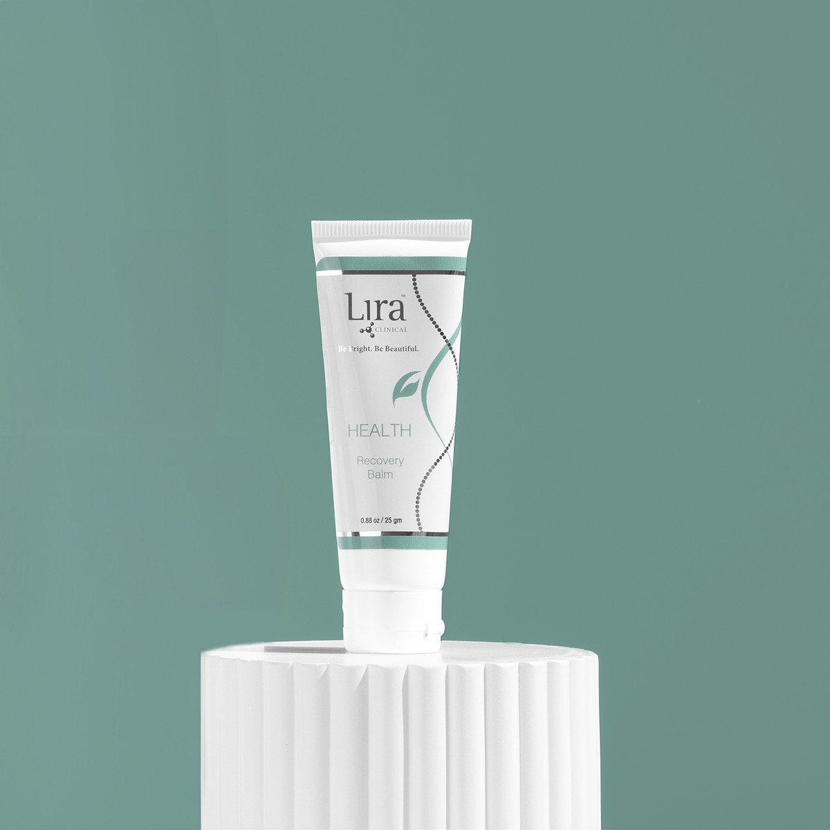 Clinical HEALTH Recovery Balm – hvit tube med teal og sølvgrå etikett og Lira Clinical-logo på hvit rillet piedestal mot teal-grønn bakgrunn, universal gjenopprettingsbalsam for sensitiv og sårbar hud, 25 g