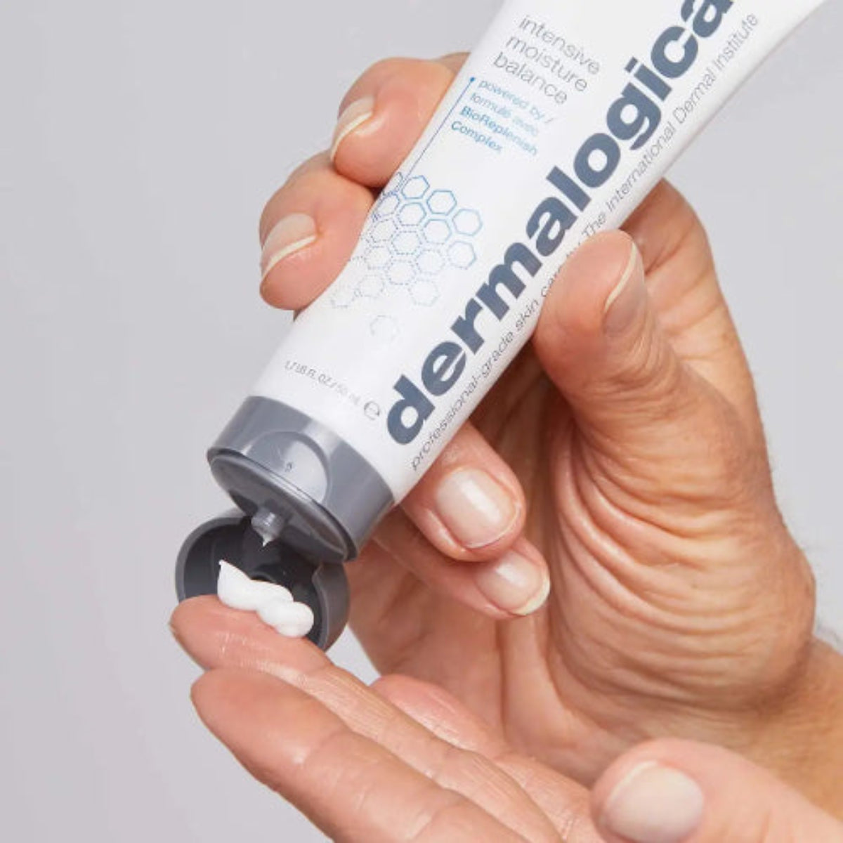 Nærbilde av hånd som dispenserer Dermalogica Intensive Moisture Balance – fuktighetskrem med BioReplenish Complex og hyaluronsyre