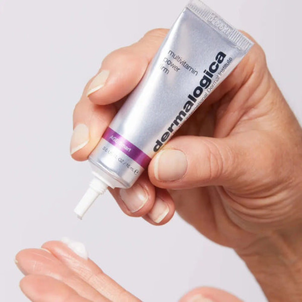Hånd som holder Dermalogica Multi-Vitamin Power Firm 15 ml tube – AGE smart oppstrammende øye- og leppebehandling mot fine linjer og rynker