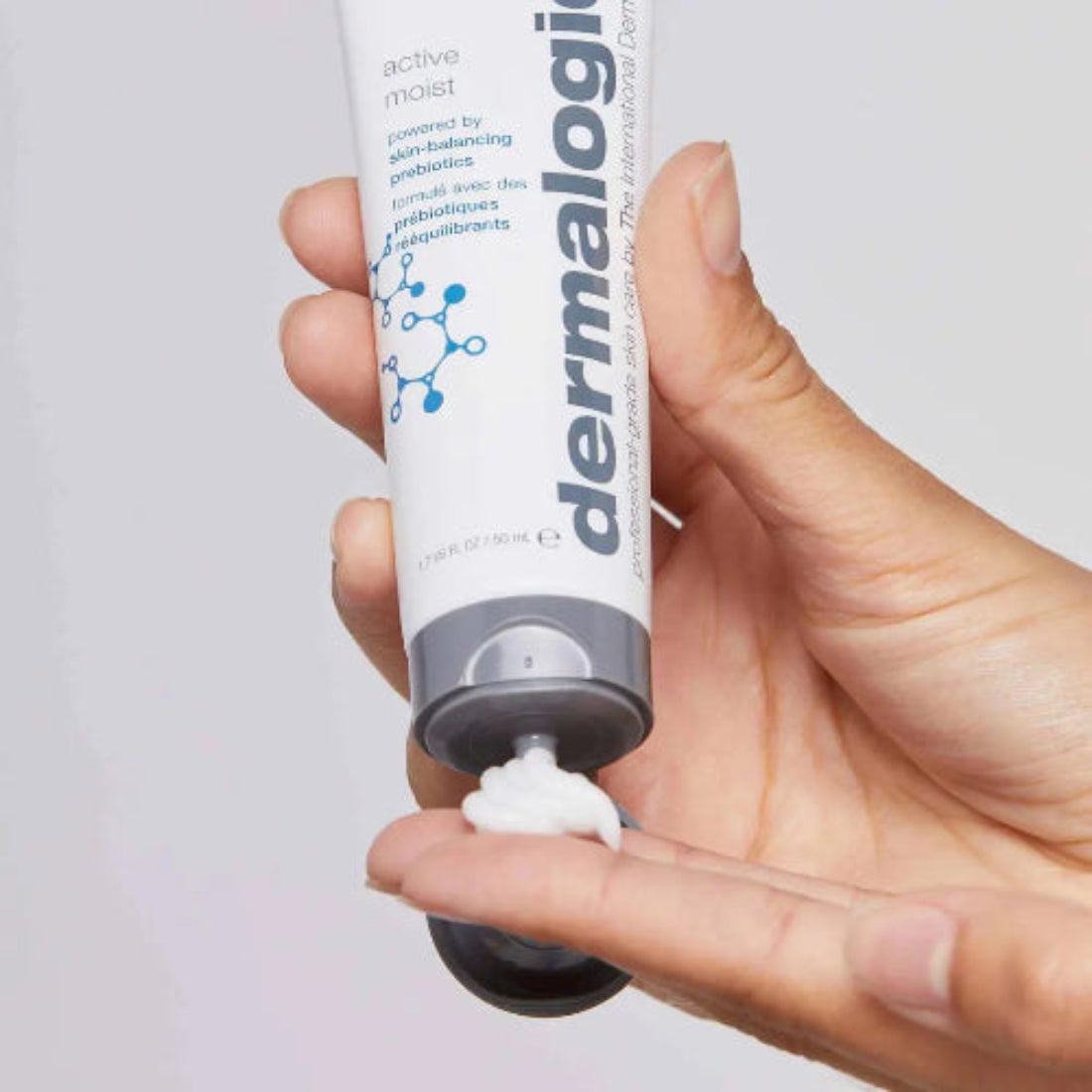 Hånd som klemmer Dermalogica Active Moist tube – oljefri prebiotisk fuktighetskrem for kombinert og fet hud, 50 ml