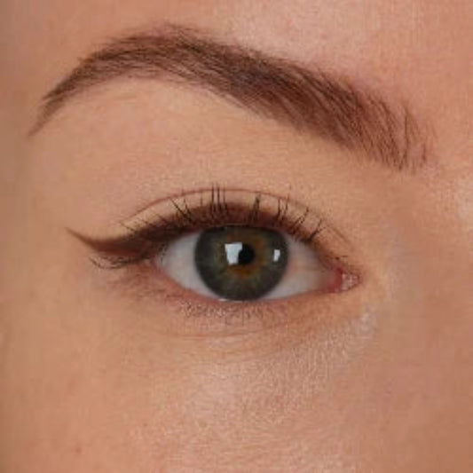 Nærbilde av et øye med lys nøytral øyenskygge og mørk eyeliner med vinge
