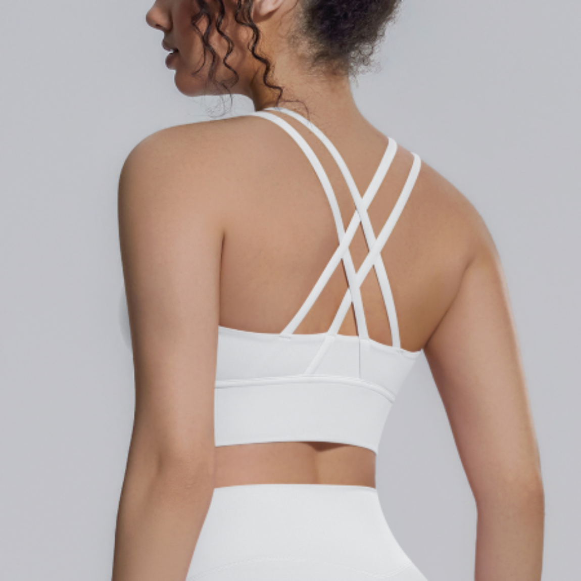Atletisk kryssrygg sports-BH i yogastil på modell bakfra – hvit sports-BH med doble kryss-stropper i 80% nylon og 20% spandex med avtakbar polstring for yoga, fitness og løping
